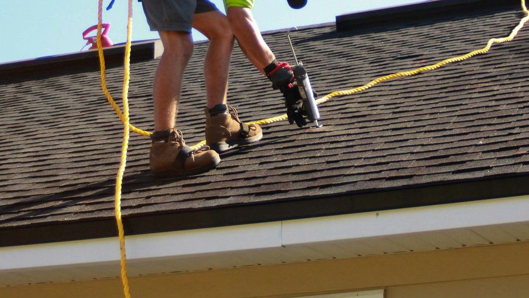 a man working on a roof with a power drill