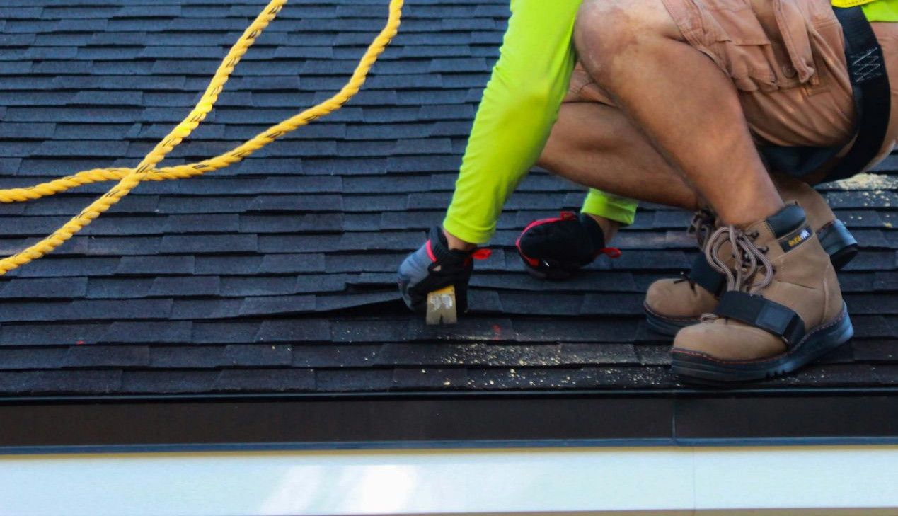 two men working on the roof of a house