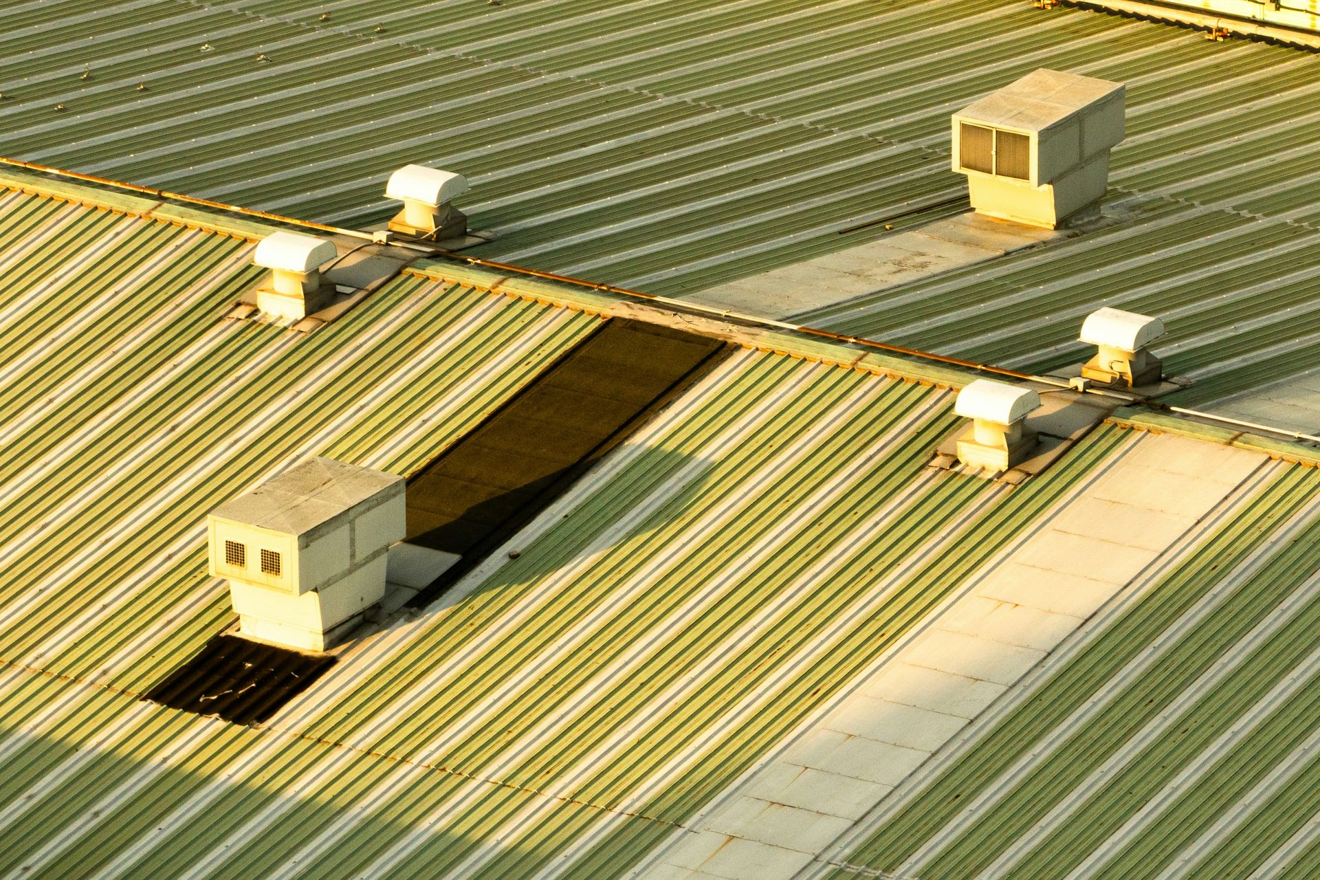 Rooftop ventilation units on a corrugated metal roof.